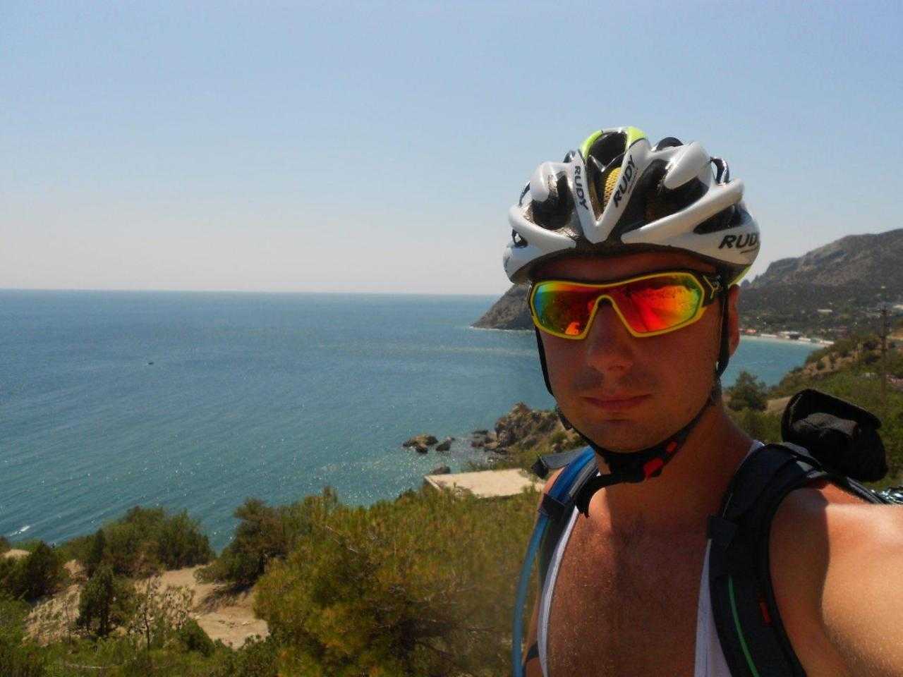 Велосипедист у моря в очках и шлеме
