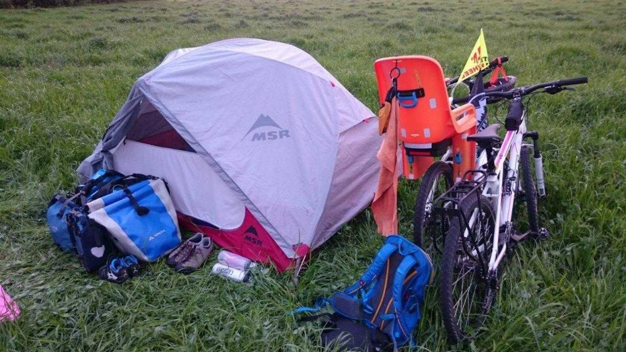 Велосипед и палатка в туристическом поле