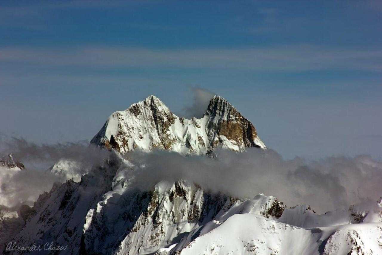 Снег и высокие горные вершины в облаках