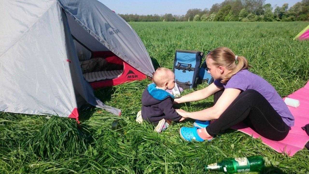 Велосипедист и ребенок в палатке в поле