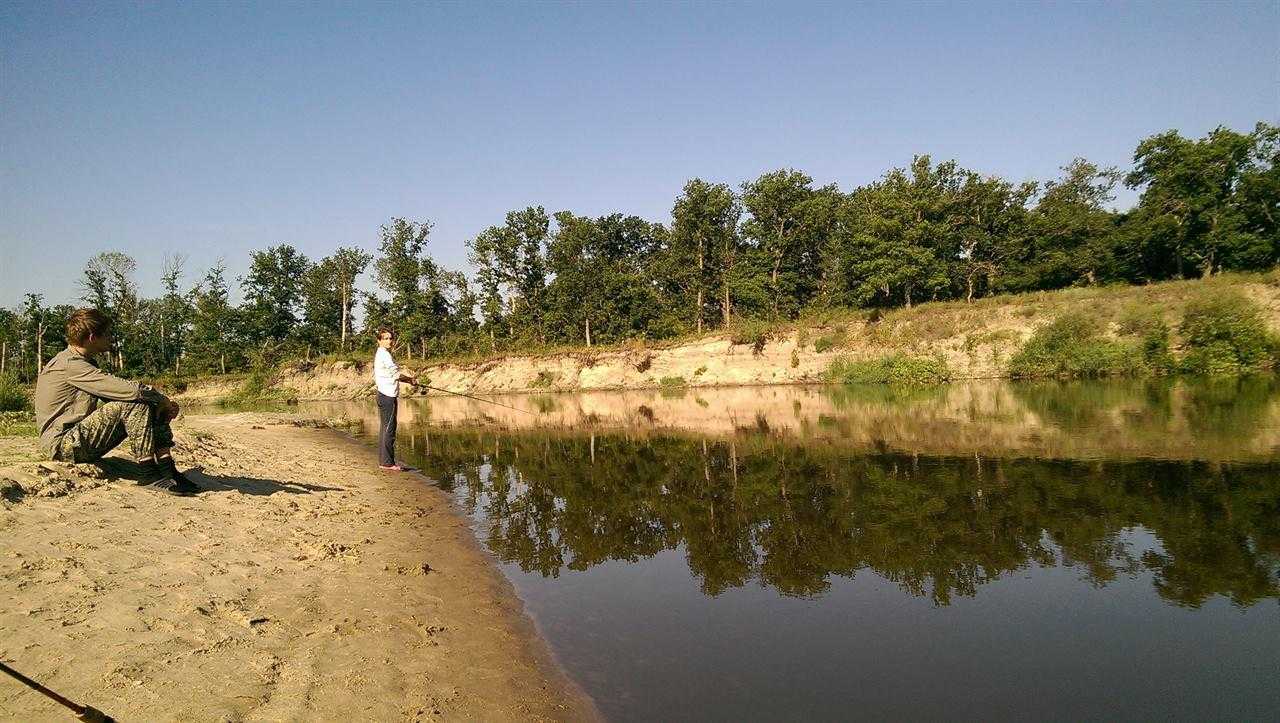 Девушка ловит рыбу в реке