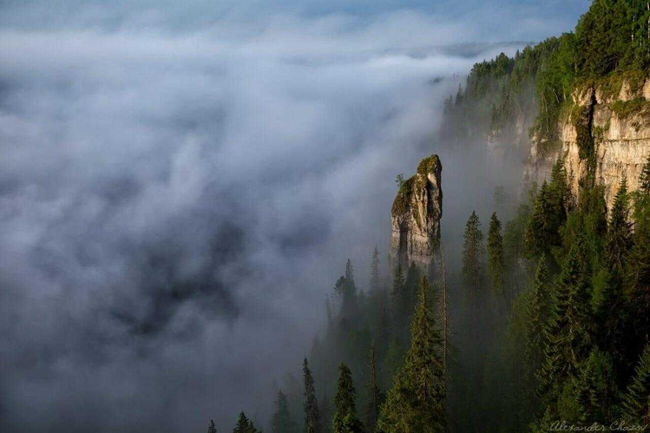 Одинокая скала в тумане над облаками